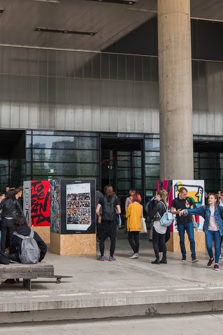 People outside looking at posters